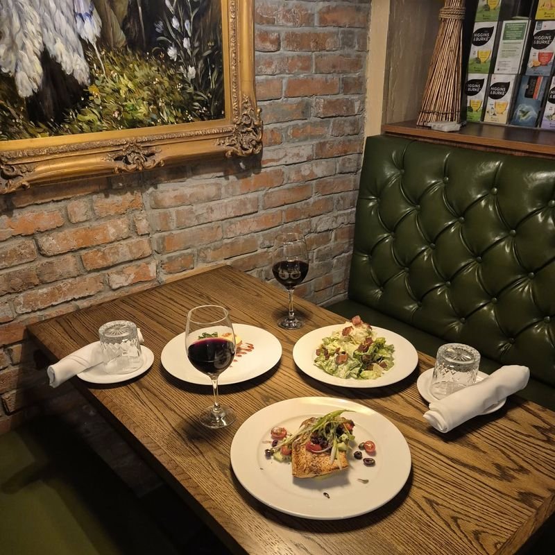 Green leather booths and a brick wall in the dining room